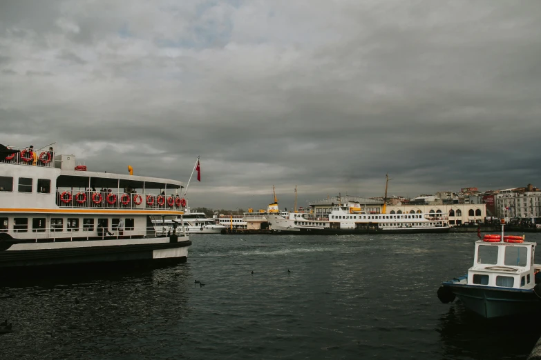 a couple of boats that are in the water, by Elsa Bleda, pexels contest winner, hurufiyya, grey skies, terminal, the fall of constantinople, thumbnail