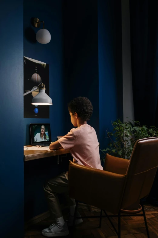 a person sitting in a chair at a desk, a hologram, inspired by Peter de Sève, unsplash, boy's room, samsung smartthings, blue accent lighting, calmly conversing 8k