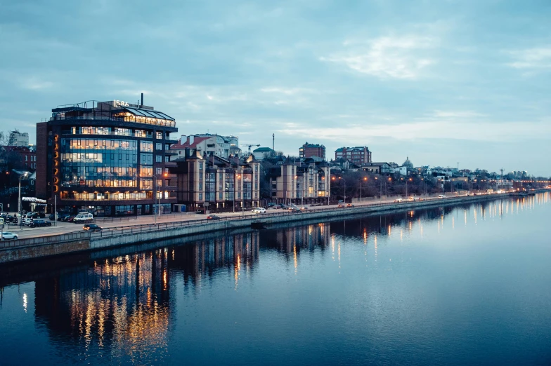 a river running through a city next to tall buildings, a photo, by Adam Marczyński, pexels contest winner, art nouveau, calm evening, berghain, panoramic, olafur eliasson