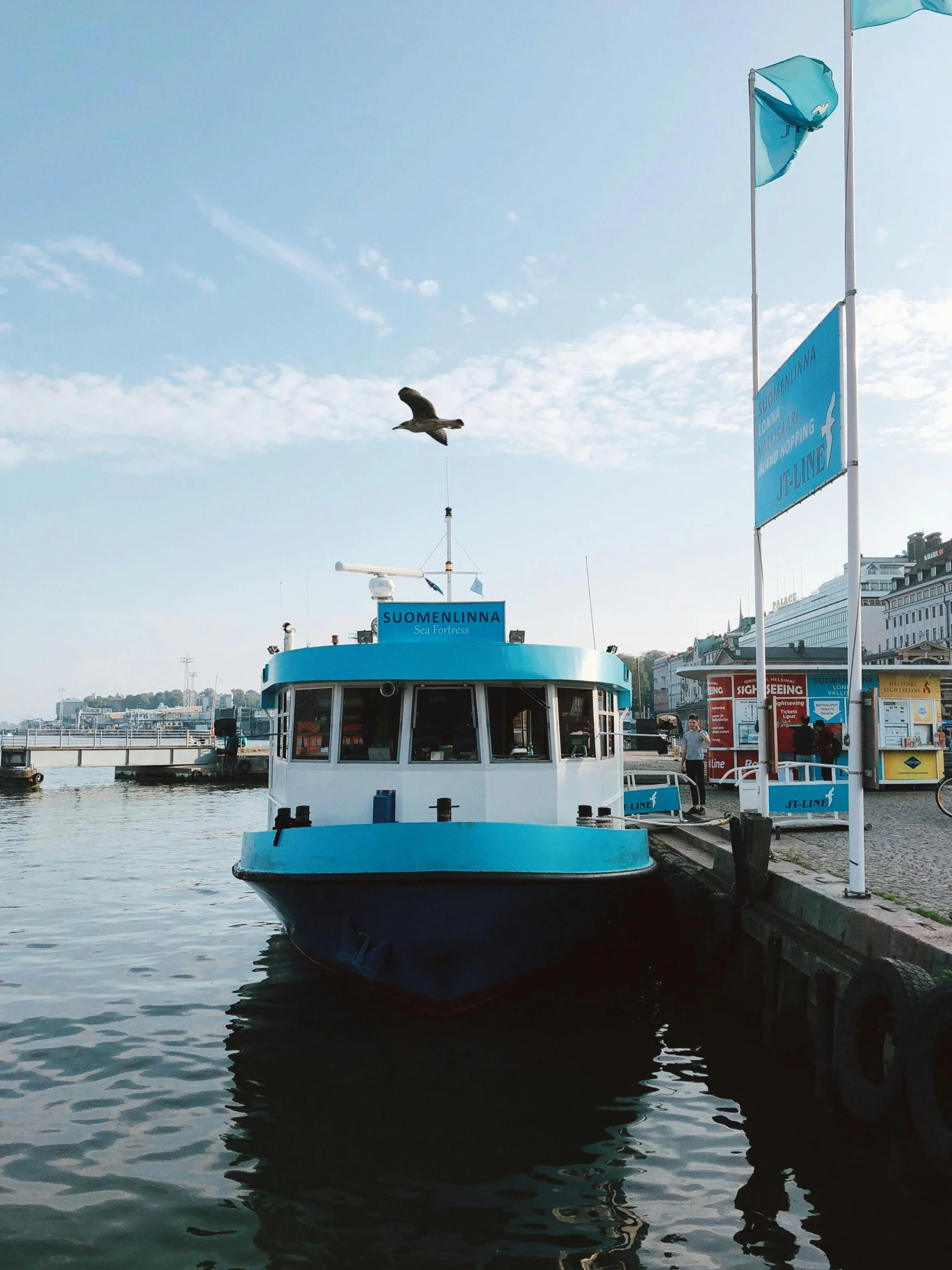 a blue and white boat sitting on top of a body of water, in the middle of the city, hamar, seagull wearing luigis hat, thumbnail