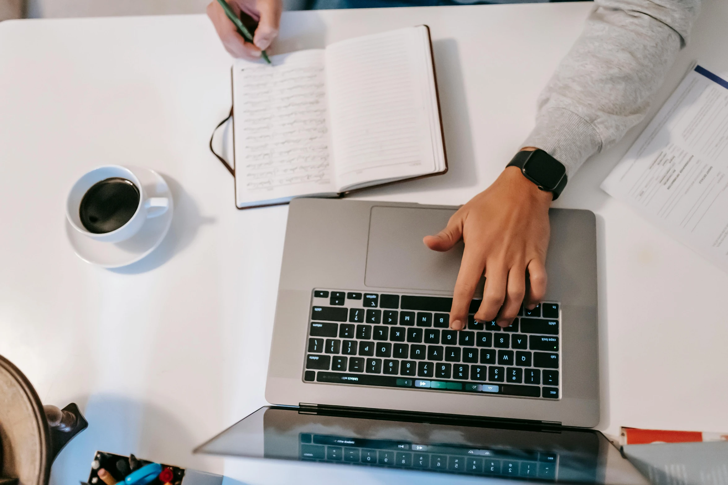 a person typing on a laptop on a desk, by Carey Morris, trending on pexels, teaching, bottom angle, student, pen and paper