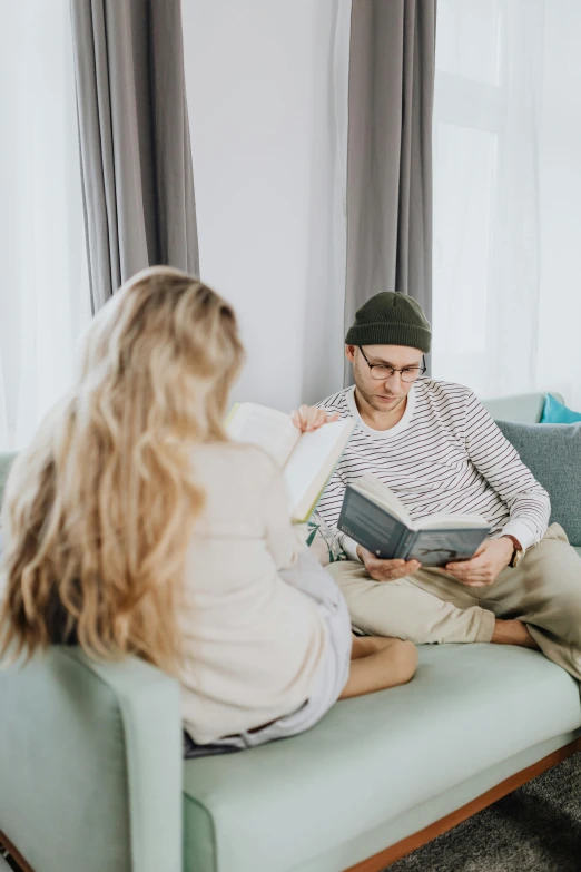 a man and woman sitting on a couch in a living room, pexels contest winner, reading the book about love, hipster dad, gif, low quality photo