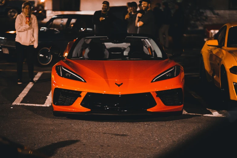 an orange sports car parked in a parking lot, pexels contest winner, cinematic front lightning, long and orange mustache, cars and people, 🦩🪐🐞👩🏻🦳