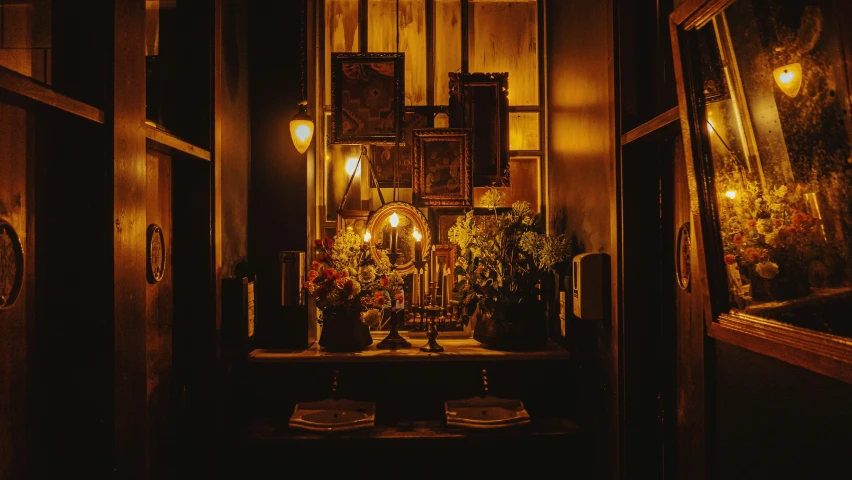 a dimly lit room with a table and pictures on the wall, a still life, unsplash contest winner, renaissance, 1 9 2 0's style speakeasy, lamps and flowers, yellow lighting from right, profile image