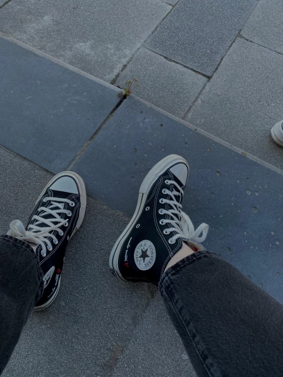 a person standing on a skateboard on a sidewalk, a picture, trending on unsplash, realism, wearing red converse shoes, 😭 🤧 💔, black! and white colors, petrol aesthetic