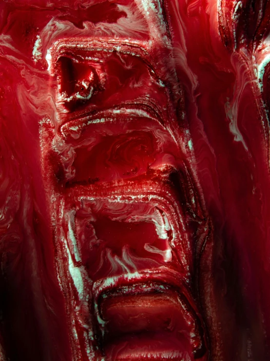 a close up of a red object on a table, a microscopic photo, inspired by Lynda Benglis, featured on zbrush central, horror saw teeth, smothered in melted chocolate, rich deep colors. masterpiec, made of glazed