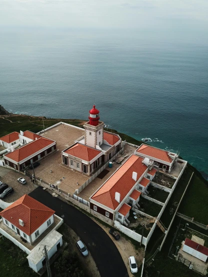 a large house sitting on top of a hill next to the ocean, farol da barra, profile image, airborne view, museum picture