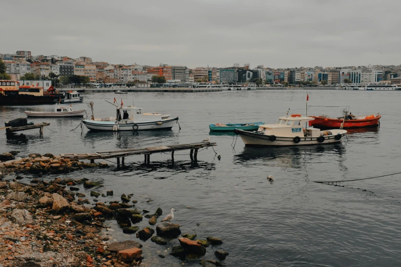 a group of boats sitting on top of a body of water, pexels contest winner, hurufiyya, overcast gray skies, mediterranean city, profile image, small dock