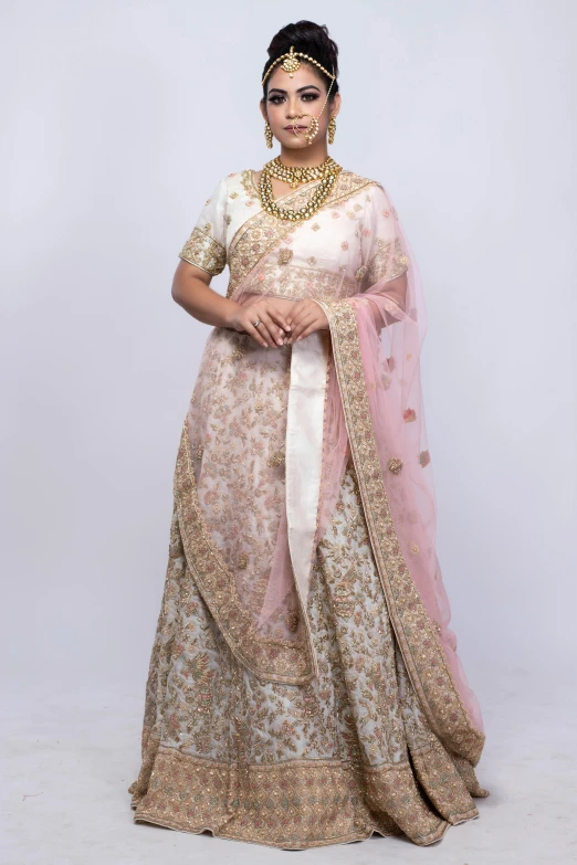 a woman in a pink and gold lehenga, by Natasha Tan, hurufiyya, in front of white back drop, silver，ivory, official store photo, square