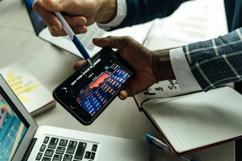 a close up of a person holding a cell phone, trending on unsplash, analytical art, square, trading stocks, working on a laptop at a desk, maths