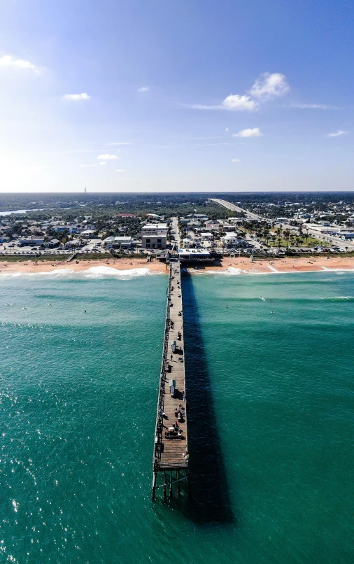 a long pier in the middle of a body of water, the emerald coast, aerial view of a city, corduroy, slide show