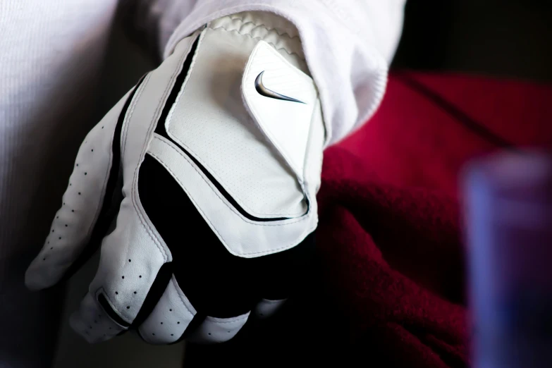 a close up of a glove on a person's hand, a digital rendering, unsplash, golf course, fabrics, swoosh, white