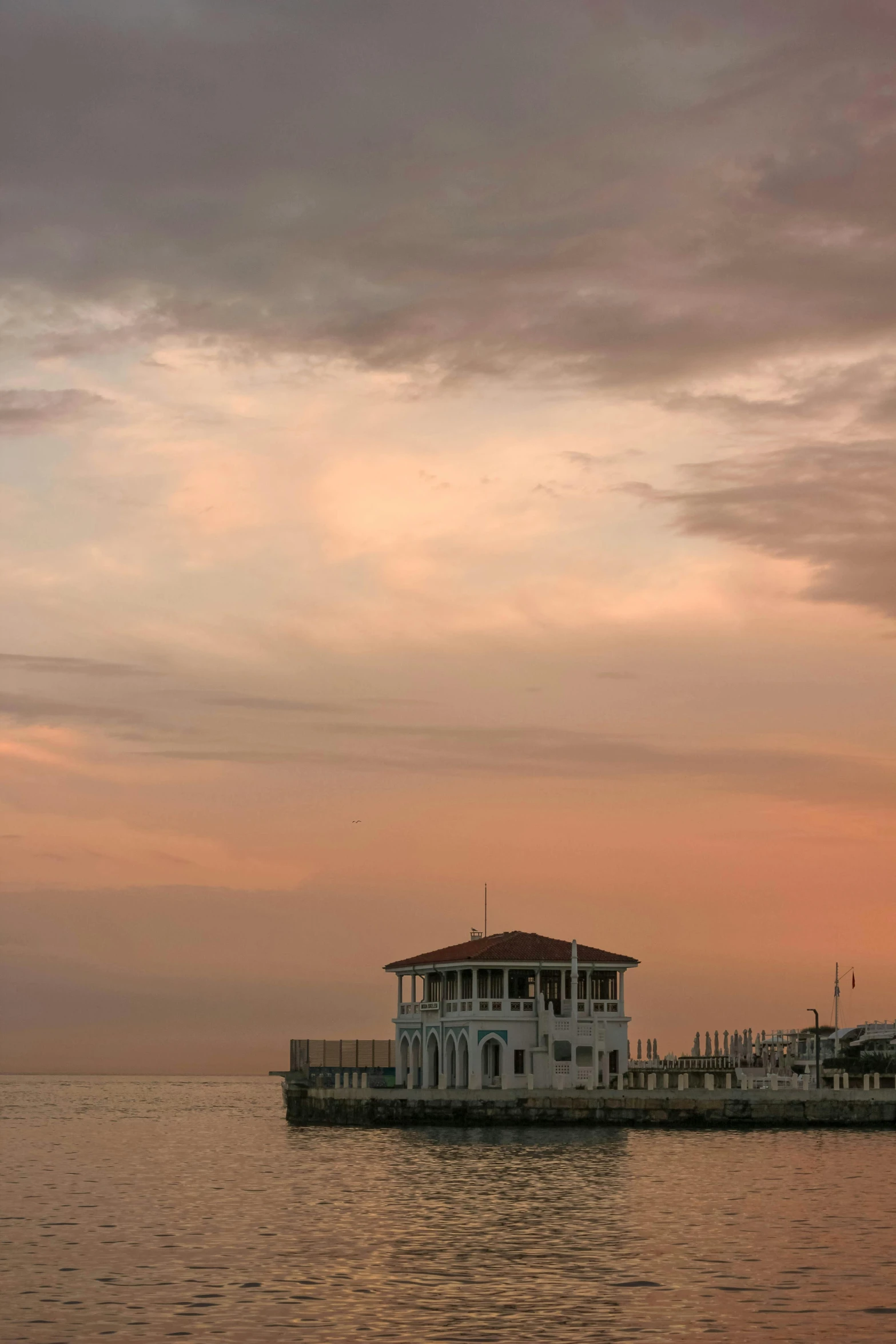 a boat that is sitting in the water, a picture, inspired by Ivan Aivazovsky, unsplash, romanticism, pastel sunset, pavilion, square, grayish