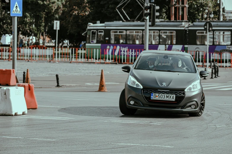 a car driving down a street next to traffic cones, by Adam Marczyński, pexels contest winner, les automatistes, glass and metal : : peugot onyx, on a street race track, gif, black quick