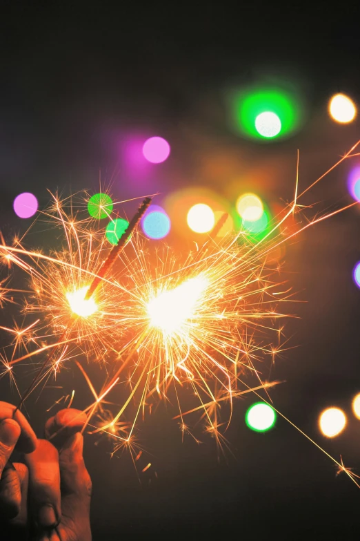 a person holding a sparkler in their hand, pexels, a brightly coloured, decorations, ilustration, multiple stories