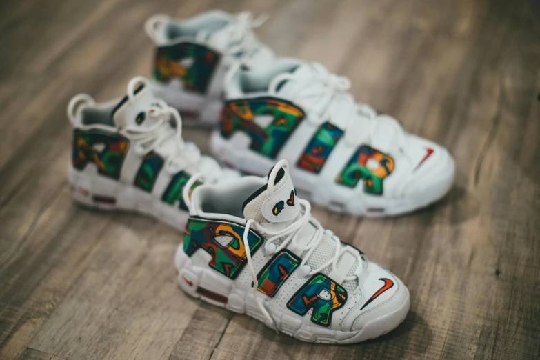 a pair of shoes sitting on top of a wooden floor, inspired by Okuda Gensō, trending on pexels, graffiti, cool white, 90s photo, robotech styling, celtics