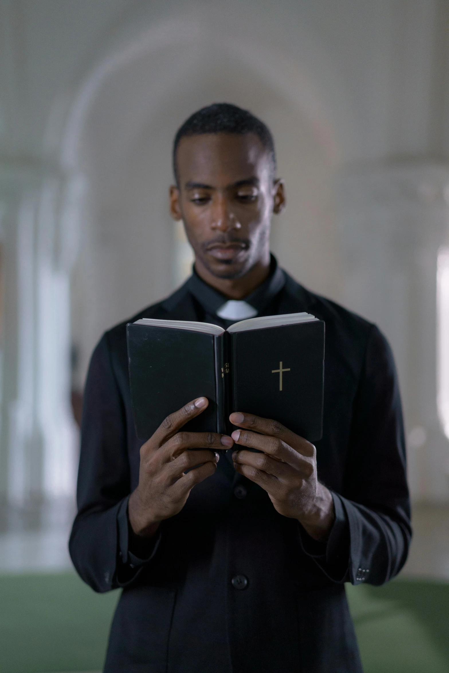 a man reading a book in a church, inspired by Gordon Parks, renaissance, still from better call saul, dark-skinned, androgynous person, high forehead