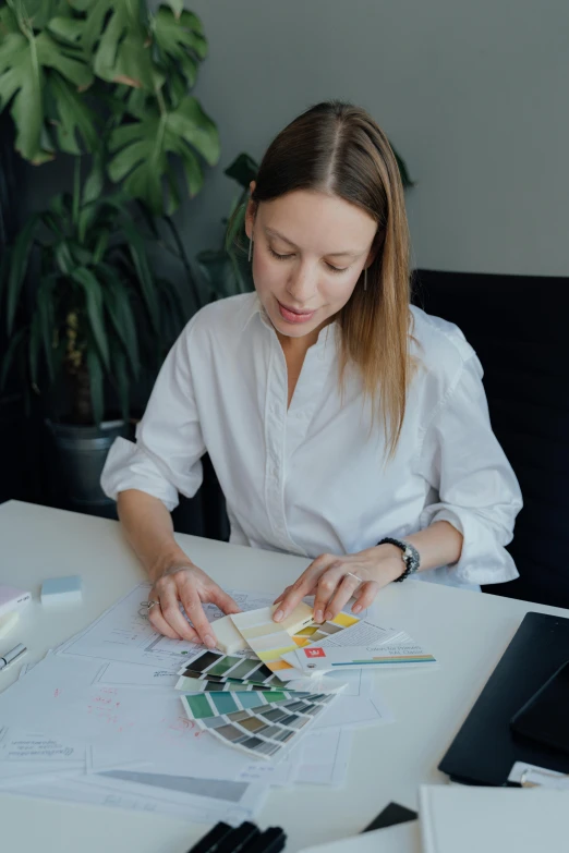 a woman sitting at a table working on a project, by Julia Pishtar, low quality photo, charts, gif, dasha taran