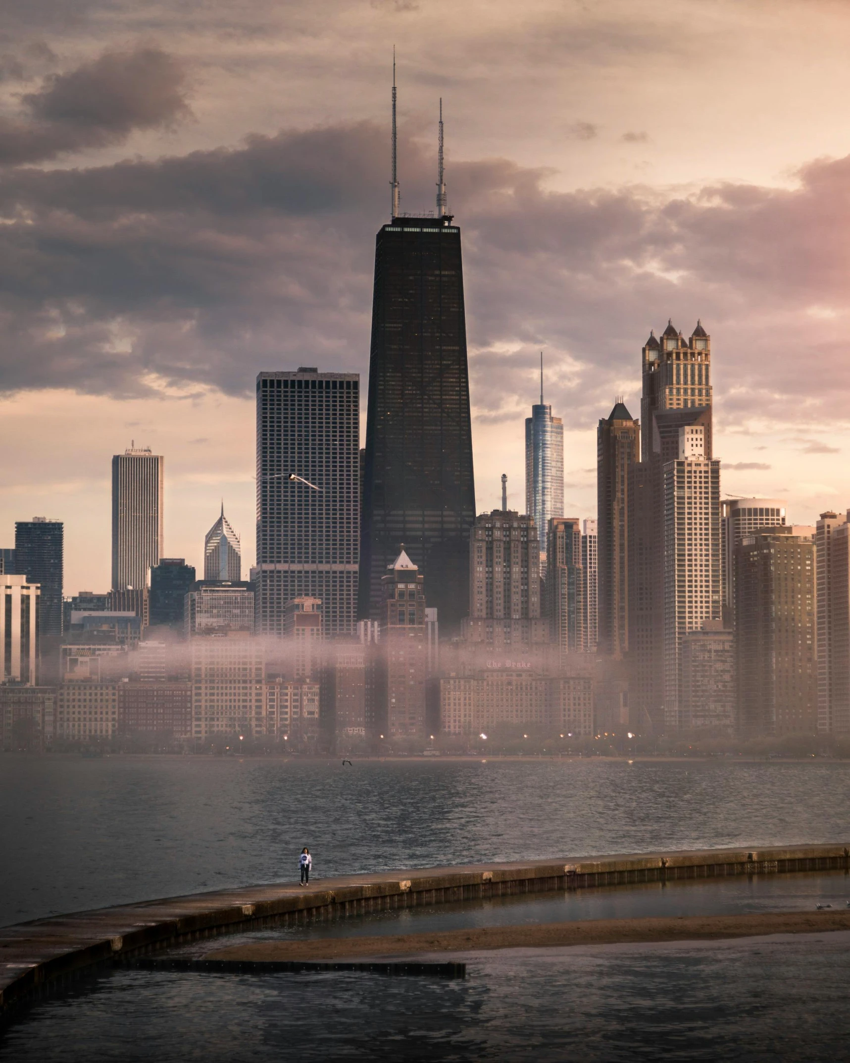 a large body of water with a city in the background, by Andrew Domachowski, pexels contest winner, light fogged, chicago, lgbtq, architecture photo