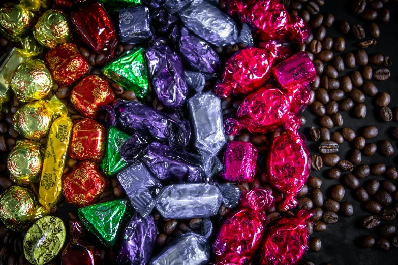 a pile of chocolates sitting on top of a pile of coffee beans, by Joe Bowler, bauhaus, vibrant iridescent, vivid vibrant colors, bells, thumbnail