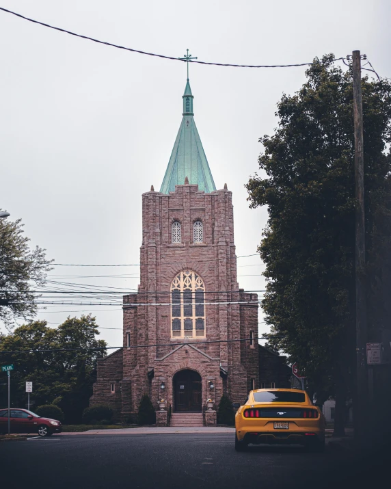 a car is parked in front of a church, a photo, unsplash, new jersey, instagram post, non-binary, grey