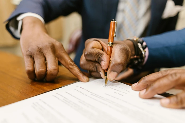 a close up of a person signing a document, by Carey Morris, pexels contest winner, renaissance, reaching out to each other, jemal shabazz, thumbnail, brown