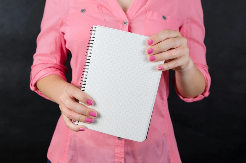 a woman in a pink shirt holding a notebook, by Julia Pishtar, pixabay, square, glossy surface, whiteboards, perfect hands