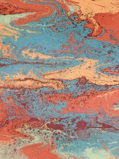 a close up of a painting on a table, an ultrafine detailed painting, inspired by Jules Olitski, red sky blue, marbled, lithography, zoomed out to show entire image