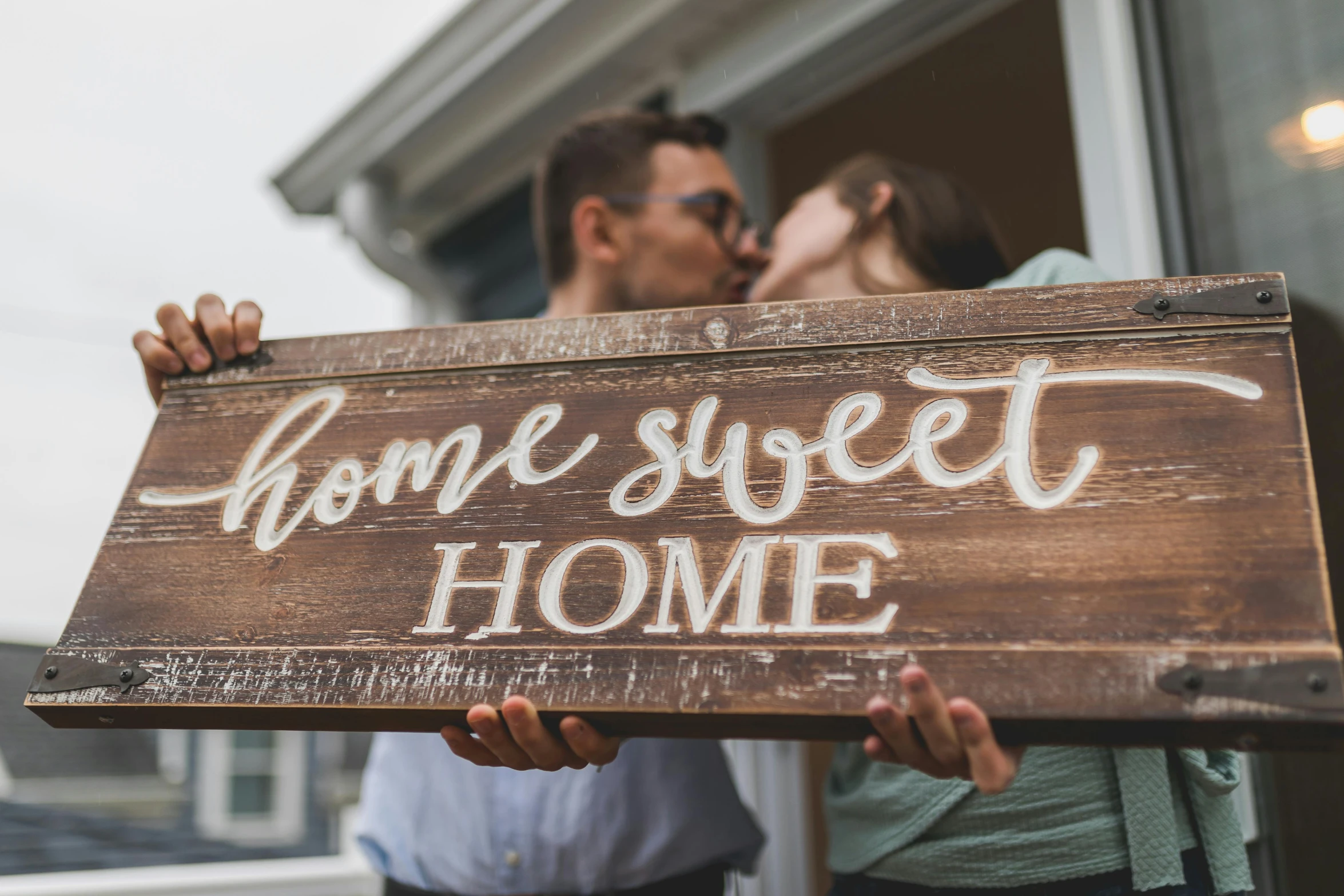 a man and woman holding a sign that says home sweet home, a photo, pexels contest winner, profile image, brown, romantic lead, multi-part