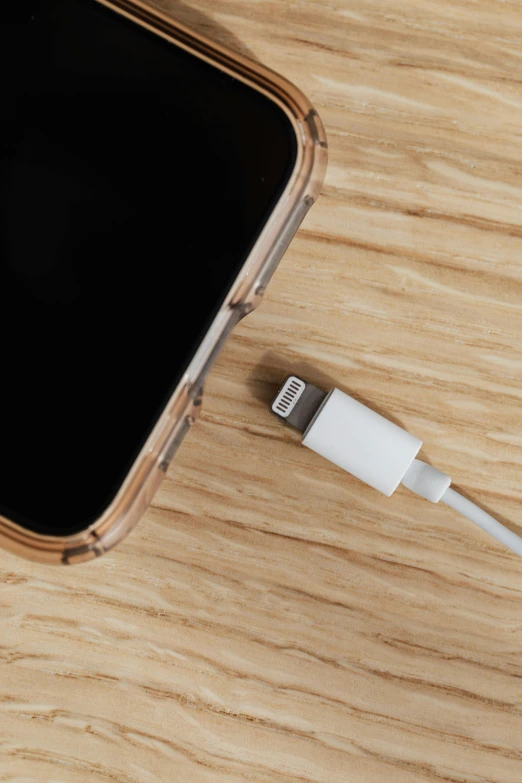 a cell phone sitting on top of a wooden table, satisfying cable management, square, transparent background, iphone 12