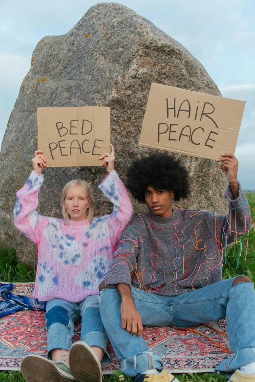 a couple of people sitting on top of a grass covered field, an album cover, pexels, renaissance, protesters holding placards, sleepwear, anya taylor - joy, at peace