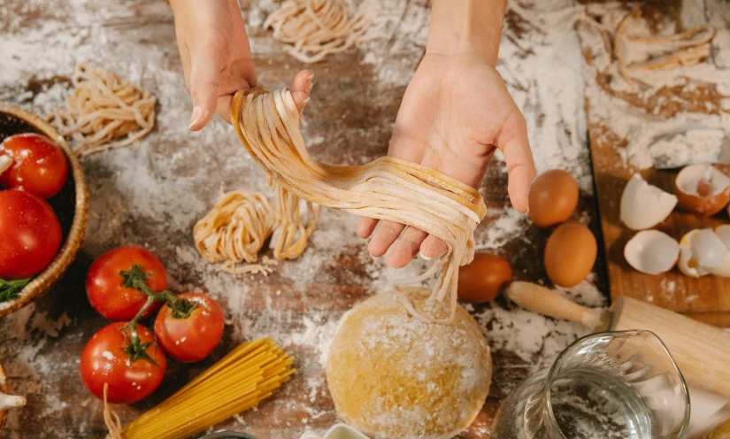 a close up of a person preparing food on a table, a picture, trending on pexels, renaissance, arms made out of spaghetti, bakery, permaculture, splash image