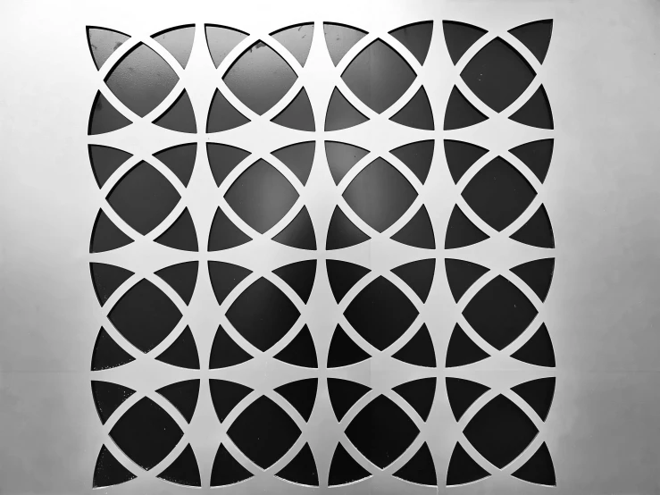 a black and white photo of a pattern on a wall, inspired by Victor Vasarely, metal panels, petals, 1 9 6 9, decorative panels