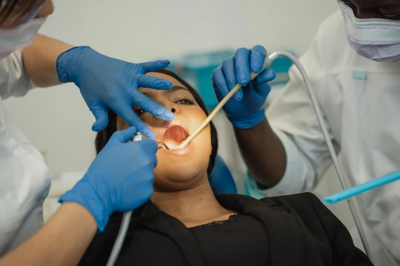 a woman getting her teeth examined by a dentist, by Lee Loughridge, pexels contest winner, hurufiyya, black, with electric arc device, multi-part, underbite