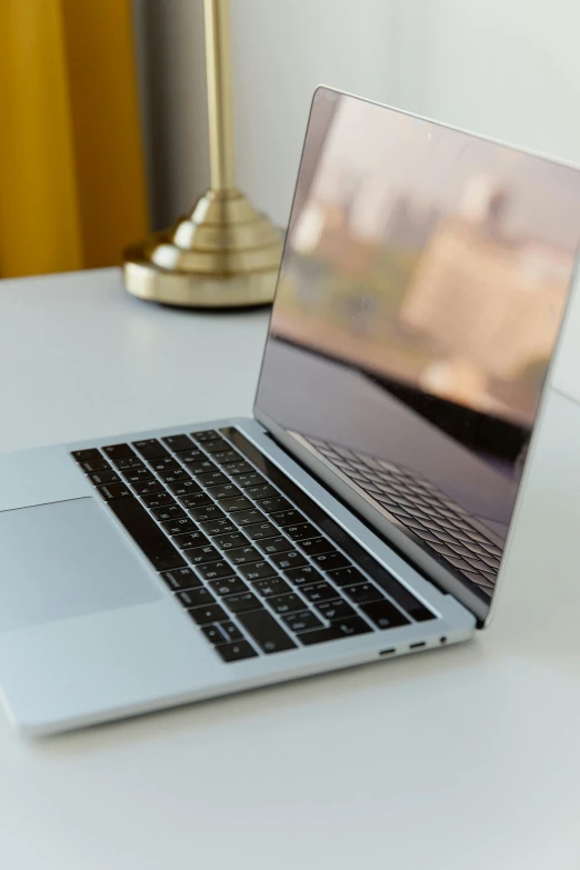 a laptop computer sitting on top of a white desk, by Robbie Trevino, shiny metallic glossy skin, thumbnail, apple, as photograph