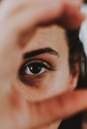 a close up of a person making a frame with their hands, trending on pexels, photorealism, brown hair and large eyes, looking in the mirror, scar under left eye, grey contacts