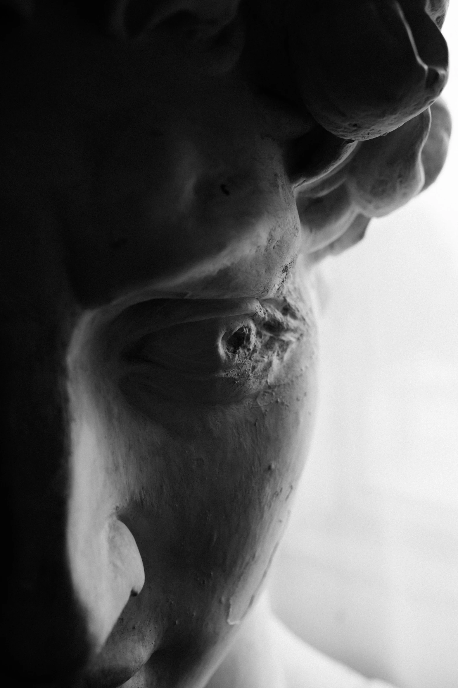 a black and white photo of a man's face, a marble sculpture, inspired by Ludovico Carracci, unsplash, hyperrealism, wound, nose made of wood, in ecstasy, close face view