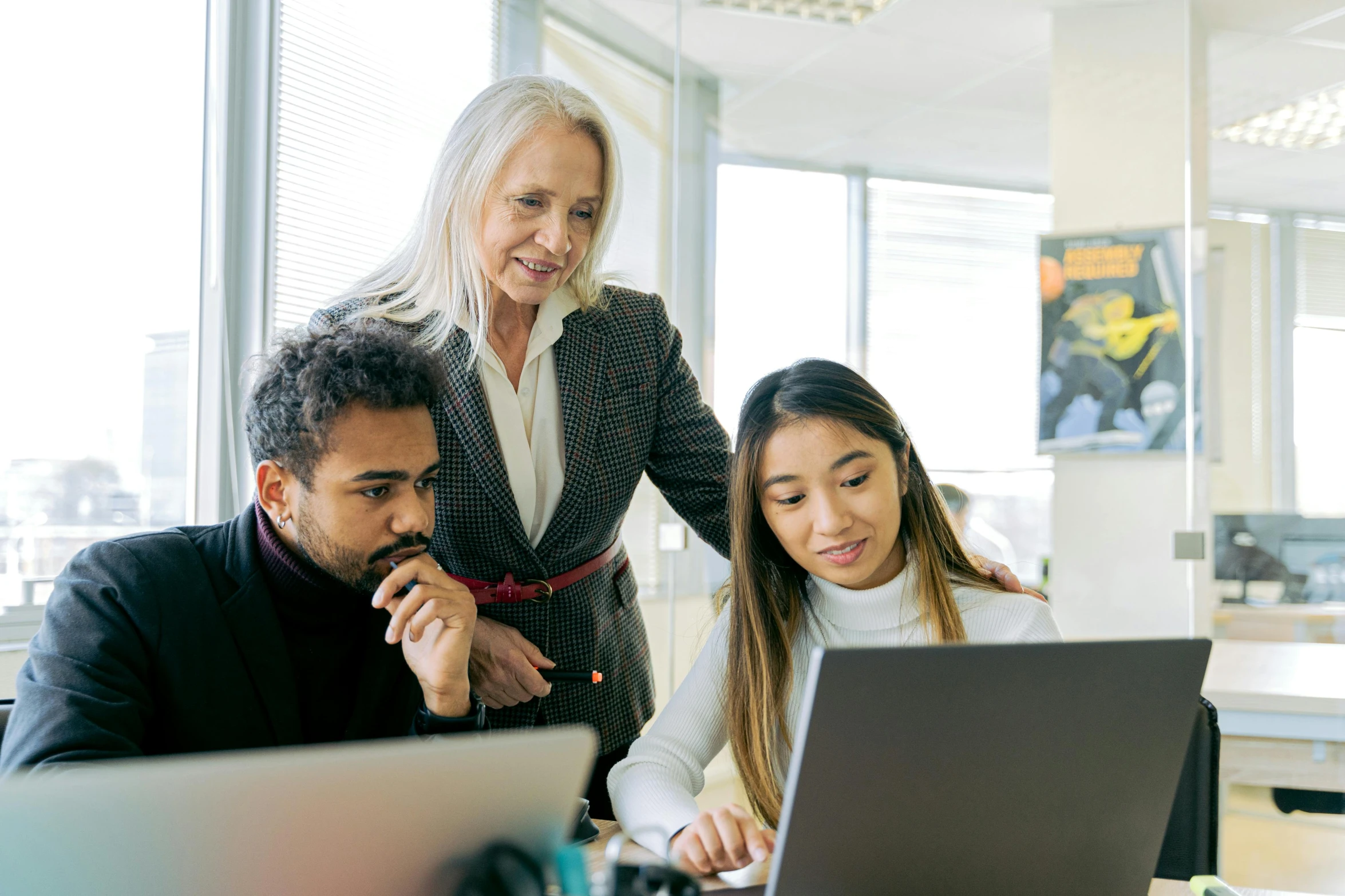 two women and a man looking at a laptop, pexels, teaching, te pae, in an office, well edited