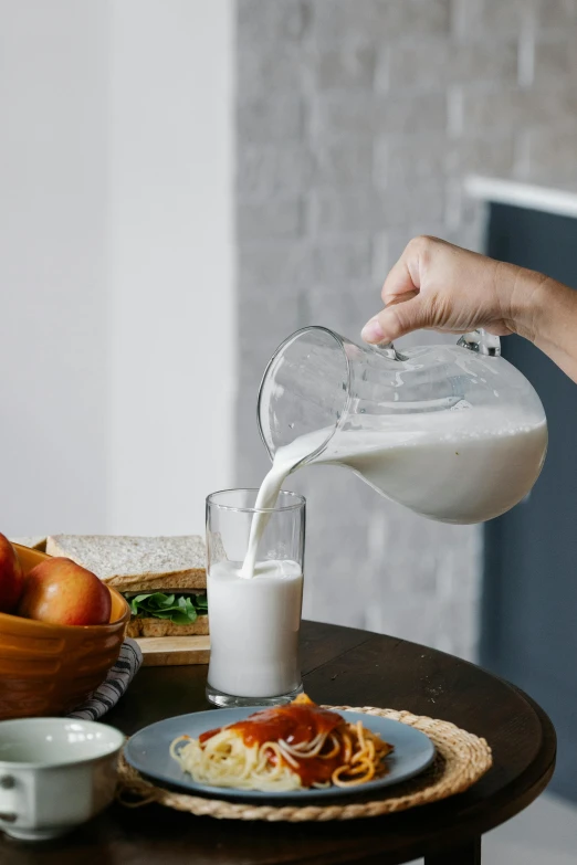 a person pouring milk into a glass on a table, detailed product image, grey, soymilk, lifestyle