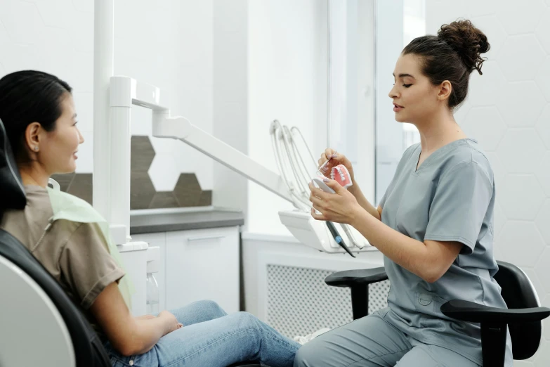 a woman having her teeth examined by a dentist, pexels contest winner, hurufiyya, manly, holding a caduceus staff, slight overcast, jodie bateman