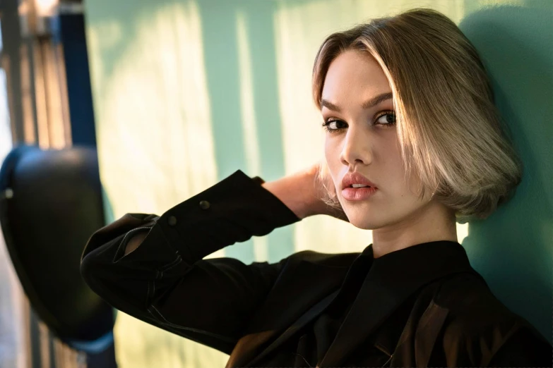 a woman leaning against a wall with her hand on her head, a portrait, unsplash, photorealism, jessica alba woman, wearing a fancy black jacket, taylor swift modeling, youtube thumbnail