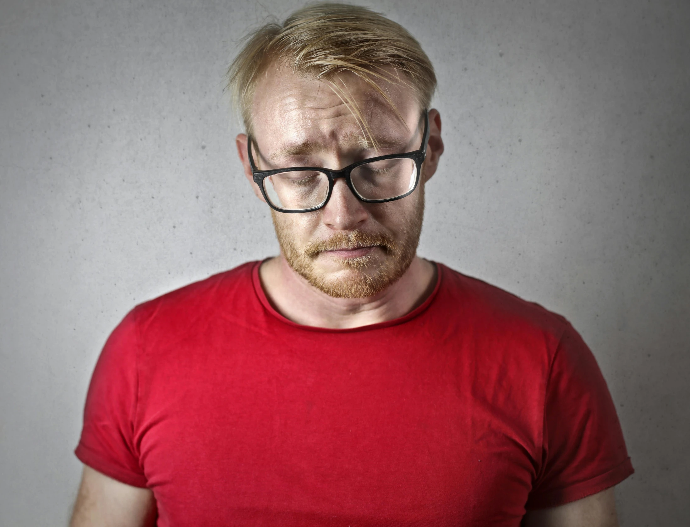 a man wearing glasses and a red shirt, pexels, sad frown, blonde guy, ouch, limmy