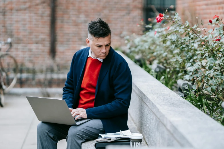 a man sitting on a bench using a laptop, trending on unsplash, academic art, wearing red formal attire, wearing a blue jacket, thumbnail, academic clothing