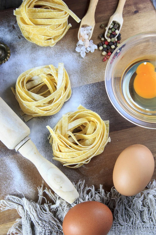 a wooden cutting board topped with pasta and eggs, renaissance, holiday season, instagram picture, essence, straining