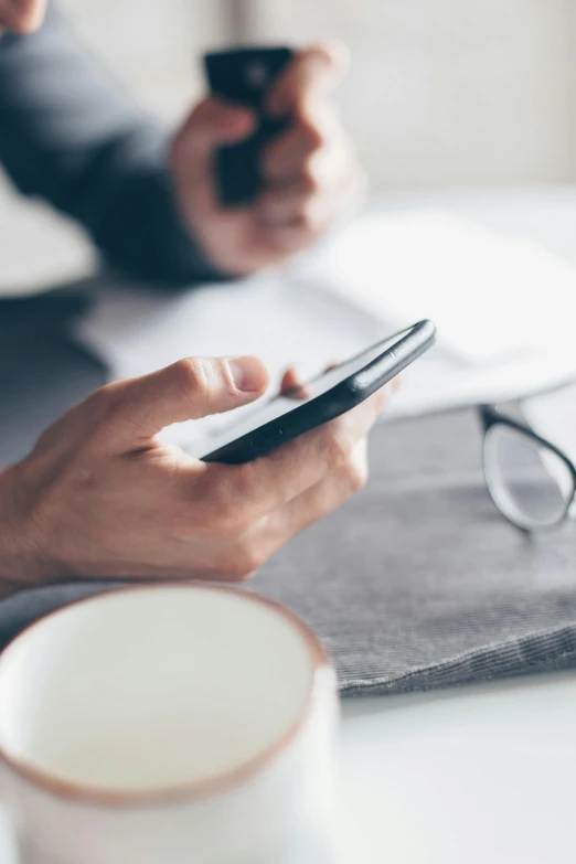 a close up of a person using a cell phone, happening, on a desk, no - text no - logo, corporate phone app icon, morning