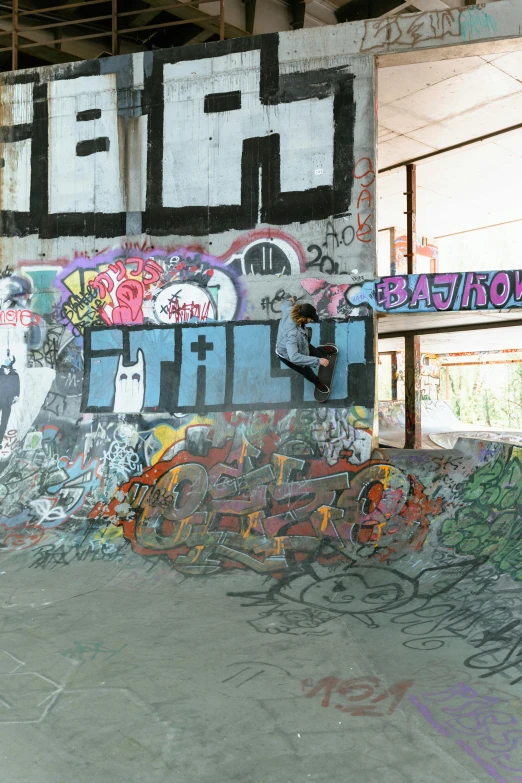 a man riding a skateboard up the side of a ramp, graffiti, ruins, sitting under bridge, tally hall, panoramic