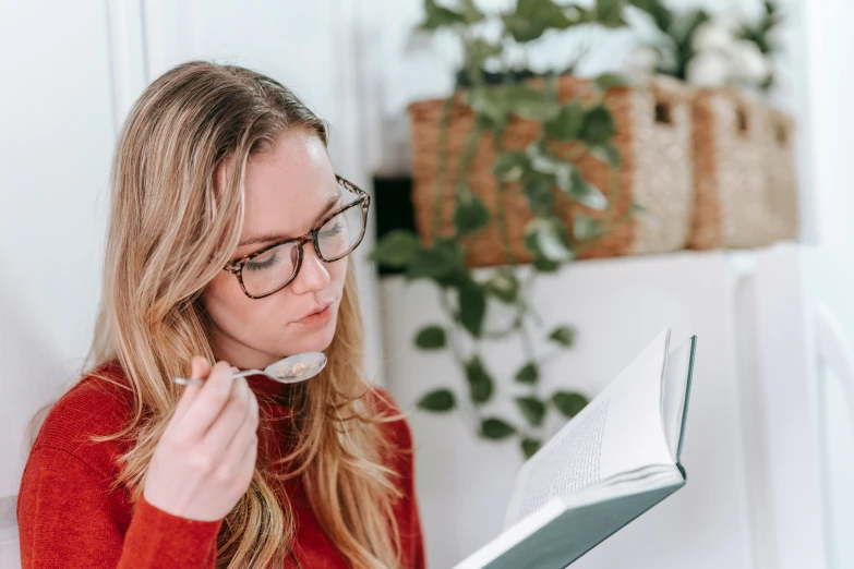 a woman in glasses is reading a book, by Nicolette Macnamara, pexels contest winner, eating spaghetti from a bowl, sydney hanson, square rimmed glasses, a super-smart