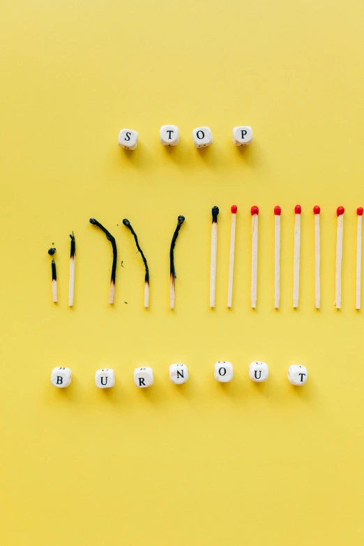 a number of matches on a yellow background, a picture, by Joseph-Marie Vien, trending on pexels, sots art, burnout, knolling, words, contracept