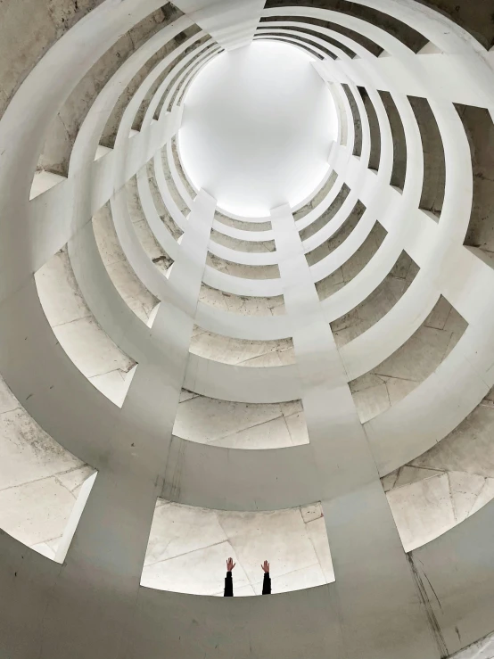 a man standing in the middle of a circular building, inspired by Anish Kapoor, light and space, white spiral horns, huge telescope on mauna kea, high-quality photo, white concrete