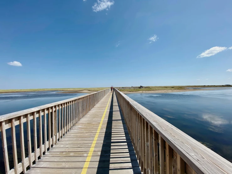 a wooden bridge over a body of water, pexels contest winner, les nabis, blue sky, craigville, wide views, slide show